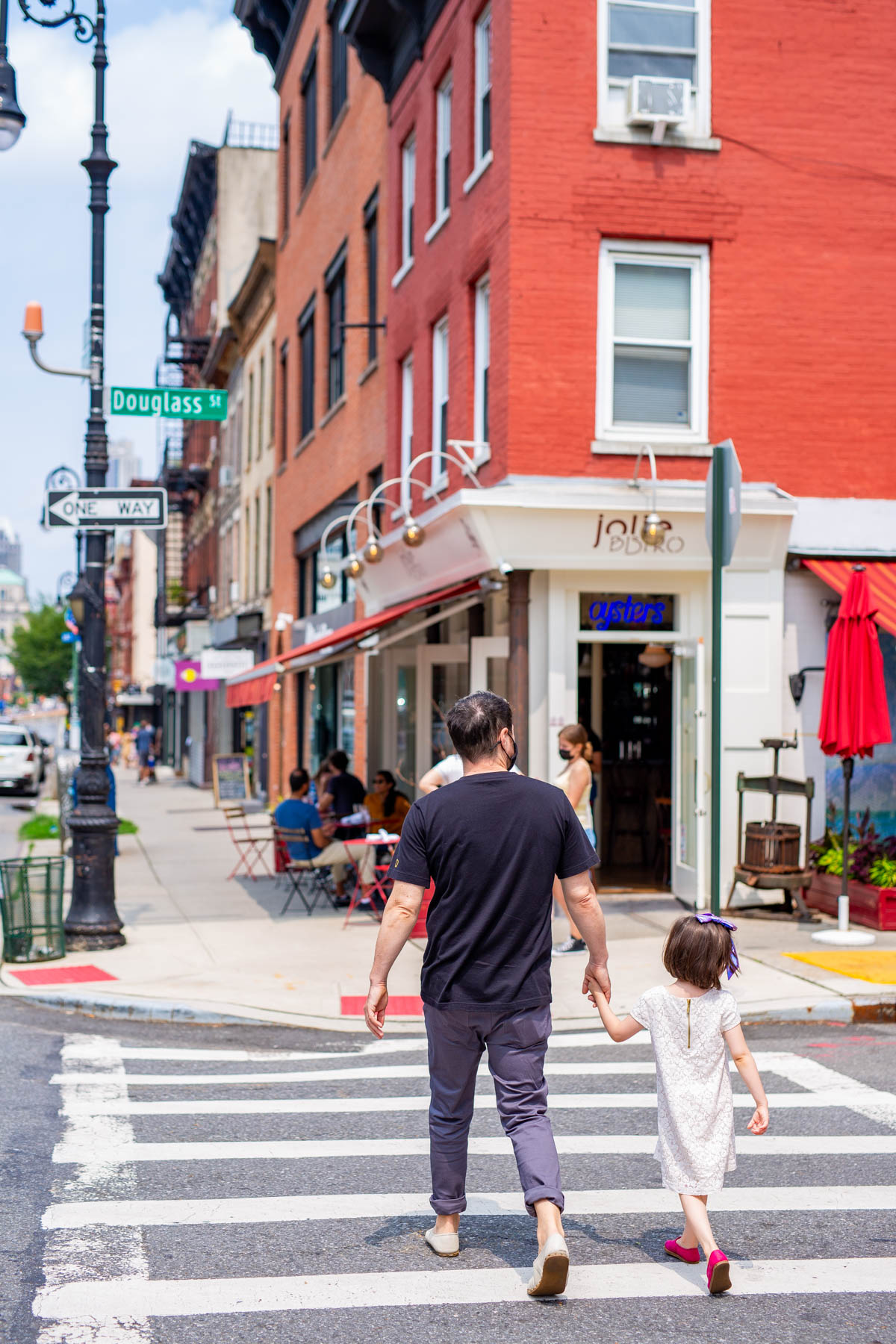 A dad crossing the street with his daughter in Carroll Gardens, one of the best NYC neighborhoods to move to