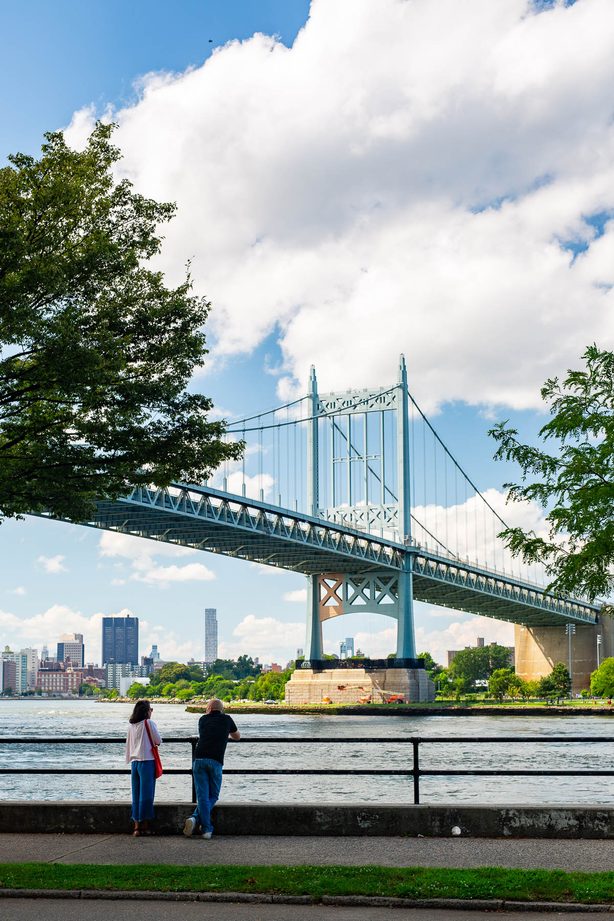Couple Looking at the Robert F. Kennedy Bridge in Astoria Park, Queens, Best neighborhoods to live in NYC