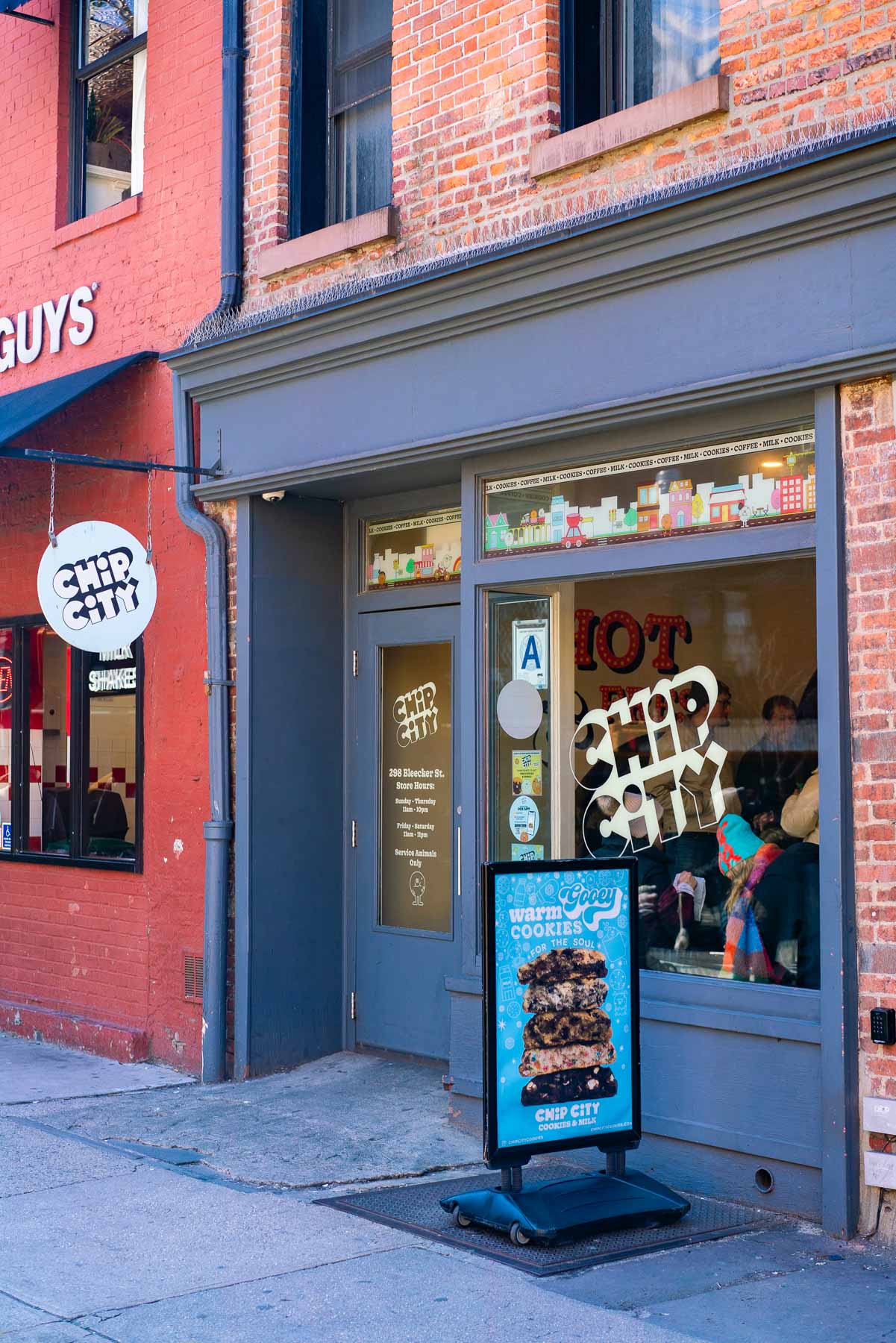 Exterior shot of Chip City in the West Village with a cookie billboard outside the door
