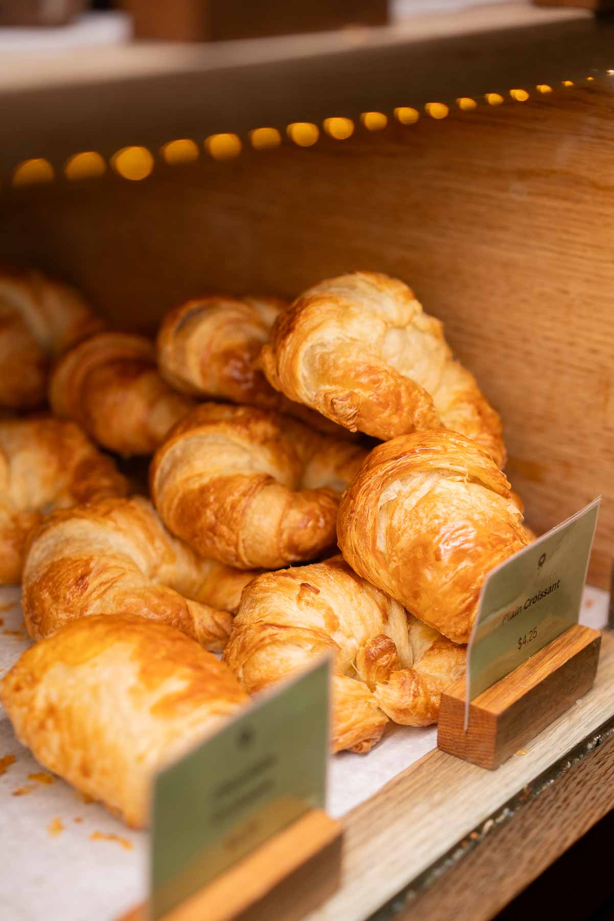 A pile of plain croissants in the display case of Kaffe Landskap in Tribeca