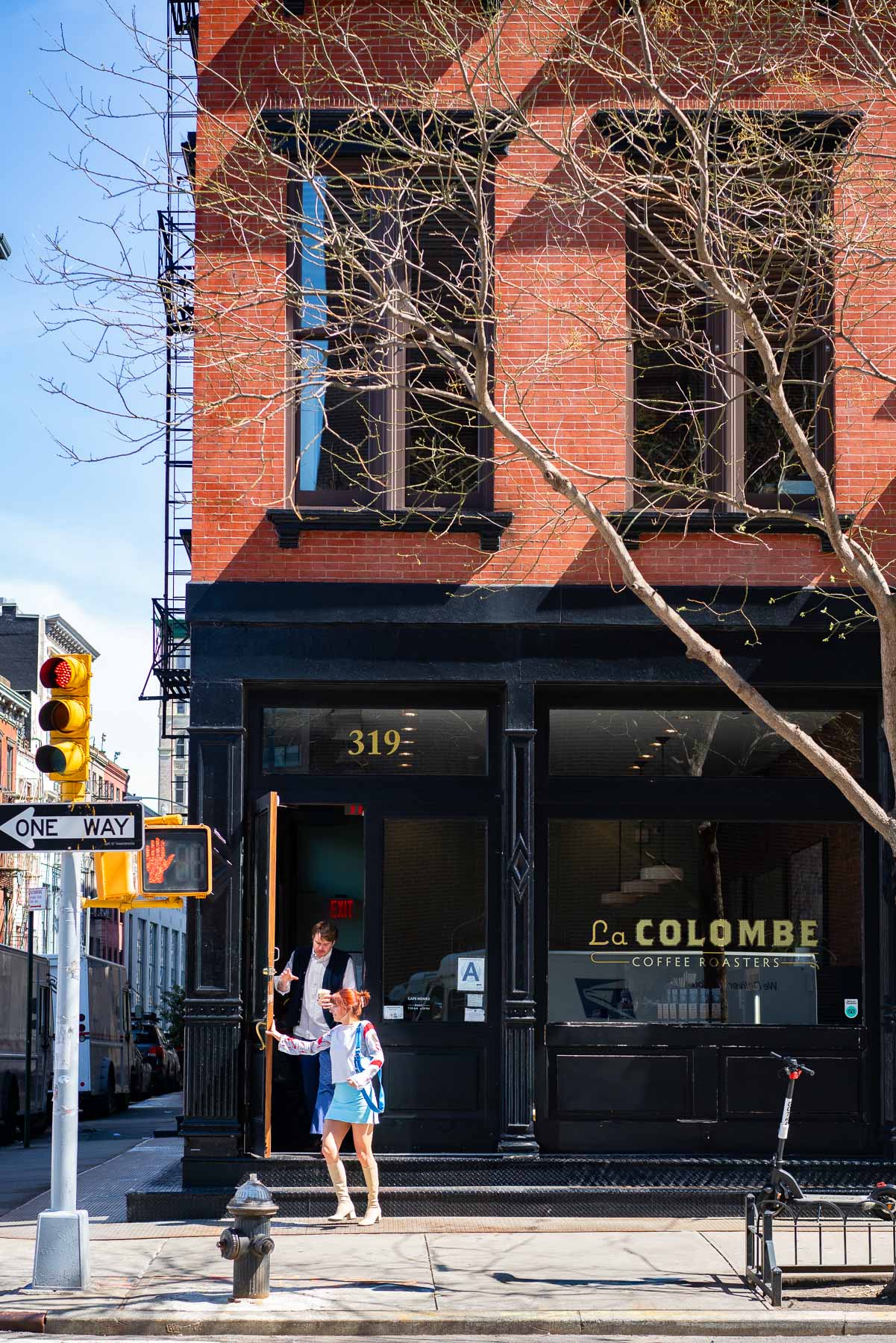 Fashionable couple walking out of La Colombe coffee shop in Tribeca